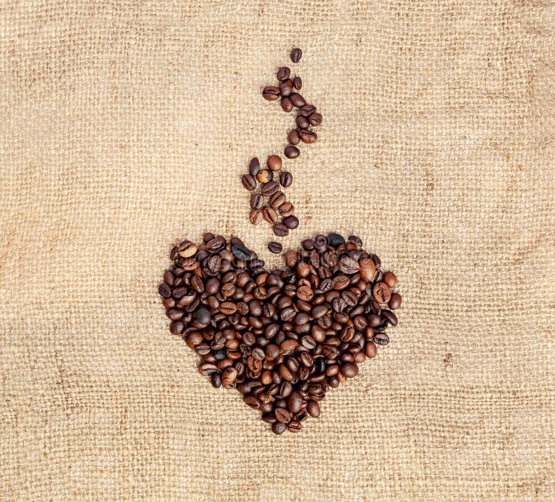 Drawing a heart with aromatic steam from coffee beans on a burlap. Vintage style. stock images Drawing a heart with aromatic steam from coffee beans on a burlap. Vintage style. stock images
