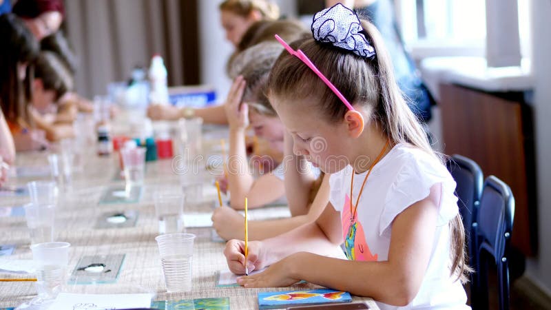 Drawing lesson, in the classroom, children draw with colors, master the technique of drawing on glass. in the foreground stock video footage