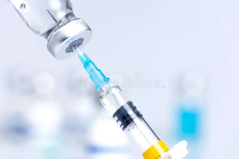 Drawing medicine out of a vial. Ampoule and syringe needle close-up shot