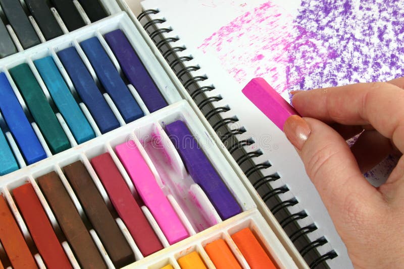 Hand of artist using pastel crayons in sketch book. Hand of artist using pastel crayons in sketch book