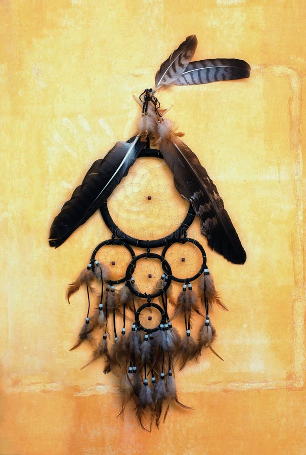 Dream Catcher with Eagle and Raven Feathers on Orange Structure Wall