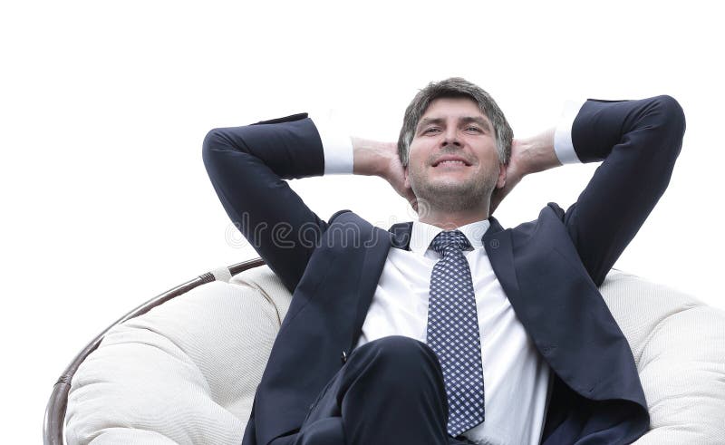 Dreaming businessman is resting, sitting in a large soft chair.