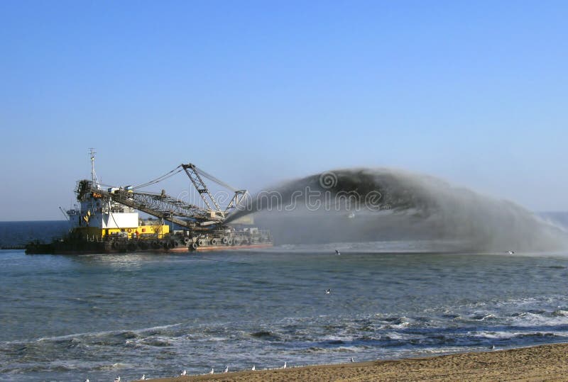 Dredger pumps sand onto beach