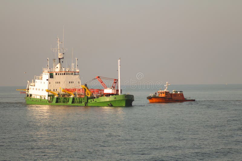 Dredger Vessel and pilot boat mooring in open sea