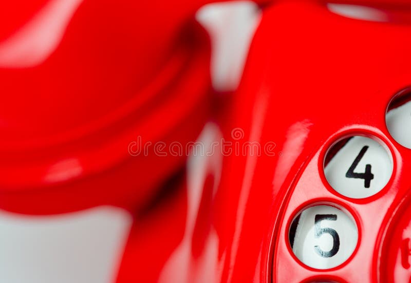 Close-up of red phone with rotary finger dial. The numbers four and five are showing in focus. Remainder of phone is blurred. Close-up of red phone with rotary finger dial. The numbers four and five are showing in focus. Remainder of phone is blurred.