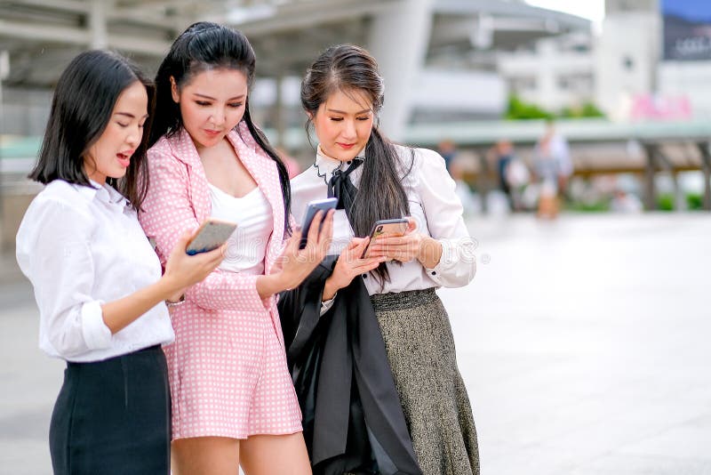 Drei asiatische Mädchen des Geschäfts über ihre Arbeiten außerhalb des Büros während der Tageszeit zusammen sich besprechen lizenzfreie stockfotografie Drei asiatische Mädchen des Geschäfts über ihre Arbeiten außerhalb des Büros während der Tageszeit zusammen sich besprechen lizenzfreie stockfotografie