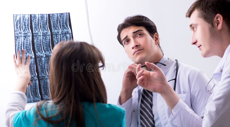 Drei Doktoren, die Scan-Ergebnisse des R?ntgenstrahlbildes besprechen stockfotografie Drei Doktoren, die Scan-Ergebnisse des R?ntgenstrahlbildes besprechen stockfotografie