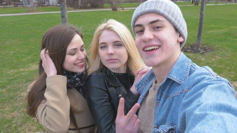 Drei Freunde, tun selfie für einen Weg im Park Blondine, Brunette und ein junger Mann Haben Sie Spaß und genießen Sie das Leben