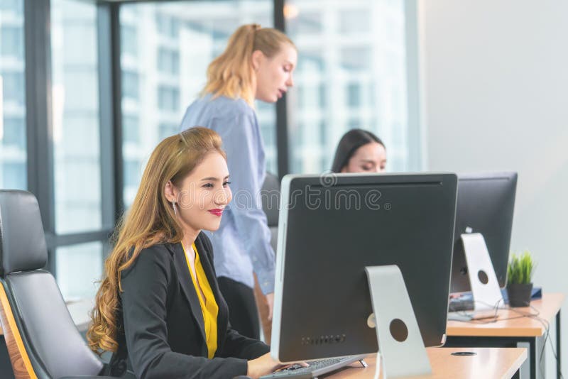 Drei Geschäftsfrauen, die glücklich im modernen Geschäftslokal arbeiten stockbilder Drei Geschäftsfrauen, die glücklich im modernen Geschäftslokal arbeiten stockbilder