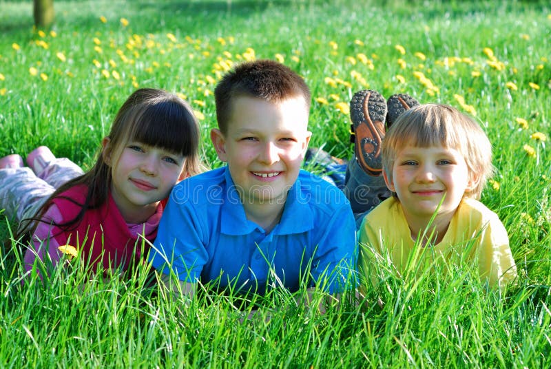 Drei glückliche Kinder in der Wiese stockfotos Drei glückliche Kinder in der Wiese stockfotos
