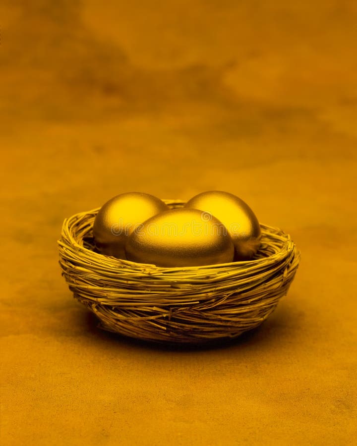 Three gold eggs in a nest with a golden tone. Three gold eggs in a nest with a golden tone