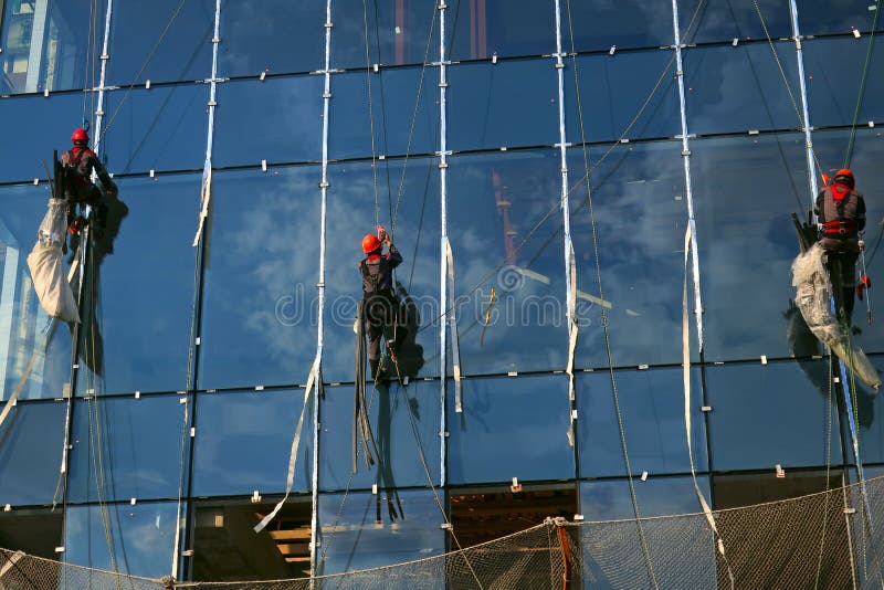 Drei Industriekletterer auf einer Glasfassade lizenzfreie stockfotografie Drei Industriekletterer auf einer Glasfassade lizenzfreie stockfotografie
