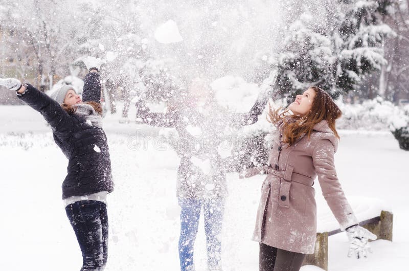 Drei Jugendlichen, die Schnee in der Luft werfen stockfotografie Drei Jugendlichen, die Schnee in der Luft werfen stockfotografie
