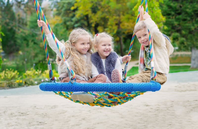 Drei Kinder, die im Park spielen stockbild Drei Kinder, die im Park spielen stockbild