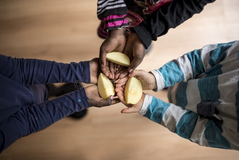 Drei Kinder von Mischrassen jede Holding ein Stück des Apfels im p lizenzfreie stockbilder