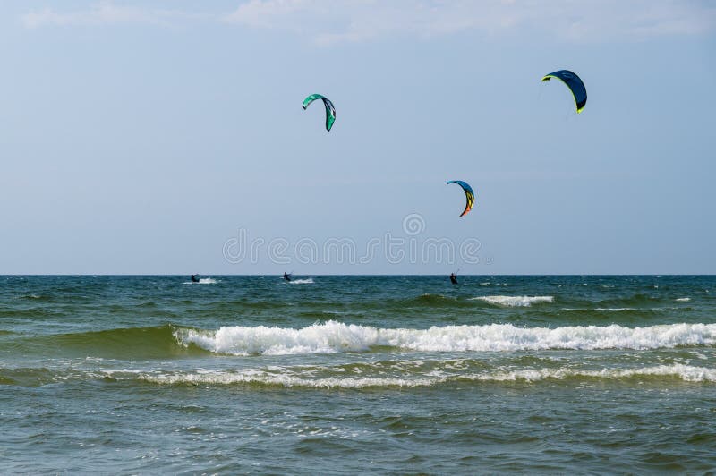 Drei kiters Fahrt auf die Wellen von Meer lizenzfreie stockfotografie Drei kiters Fahrt auf die Wellen von Meer lizenzfreie stockfotografie