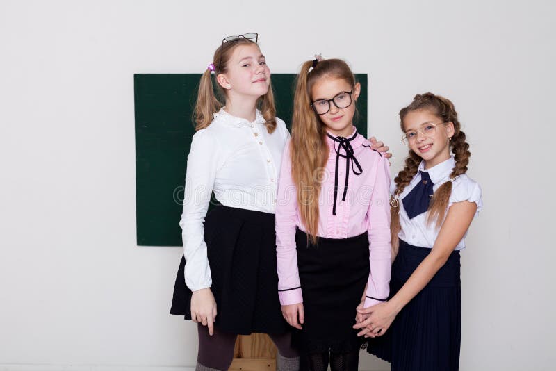 Drei Mädchen in der Klasse auf der grünen Tafel lizenzfreies stockfoto