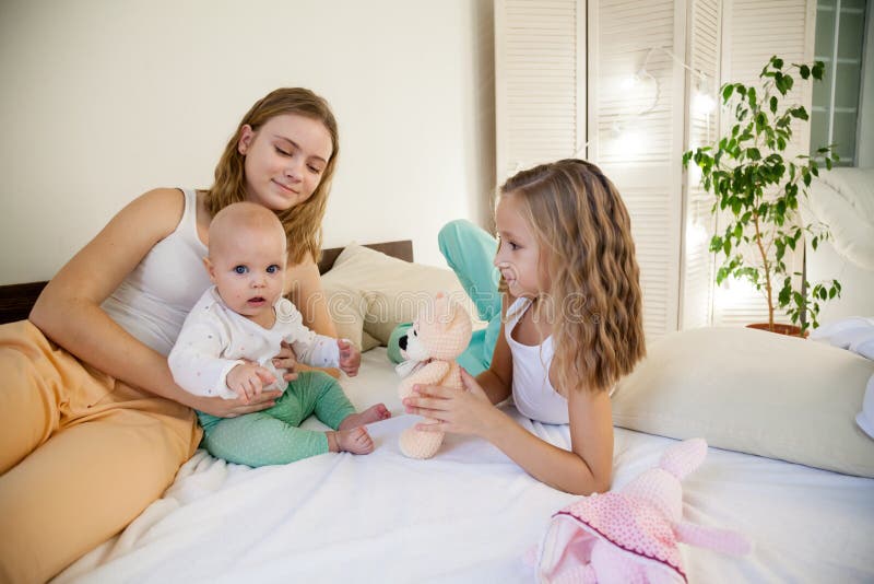 Drei Mädchenspielschwestern morgens im Schlafzimmer stockfotos