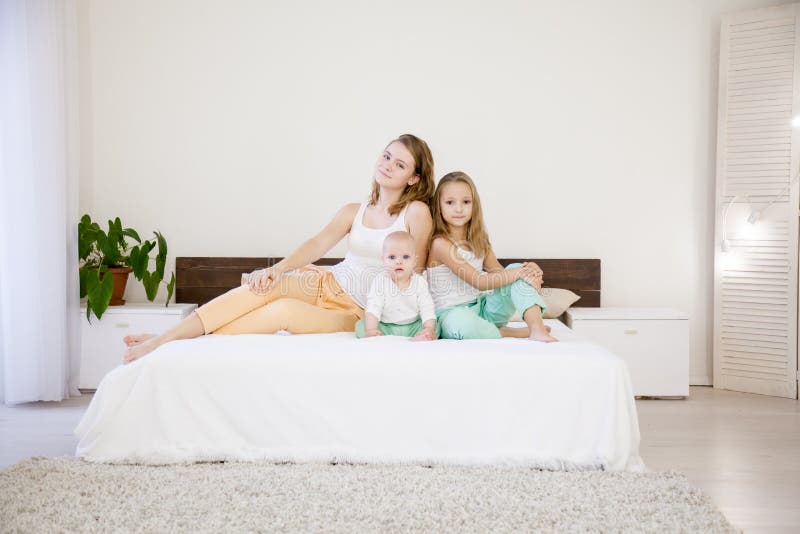 Drei Schwestern auf dem Bett im Schlafzimmer morgens lizenzfreie stockfotos