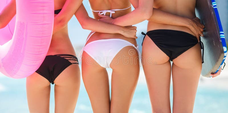 Drei schöne junge Frauen auf dem Strand in einem Bikini
