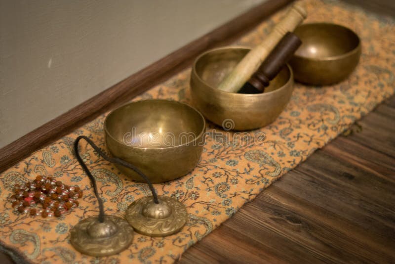 Three sound bowl on wooden floor with drumstick and other accessories for sound bowl meditation. Three sound bowl on wooden floor with drumstick and other accessories for sound bowl meditation