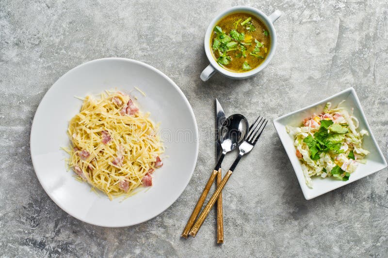 Drei Teller im Restaurant, in den Teigwaren Carbonara, im gr?nen Salat und in der H?hnersuppe lizenzfreie stockfotografie Drei Teller im Restaurant, in den Teigwaren Carbonara, im gr?nen Salat und in der H?hnersuppe lizenzfreie stockfotografie