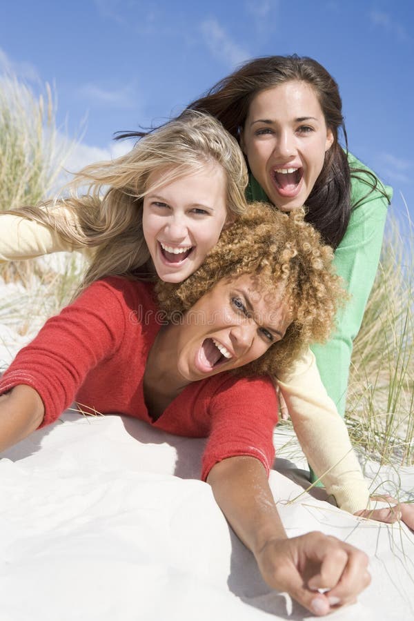 Drei weibliche Freunde, die Spaß am Strand haben stockbilder Drei weibliche Freunde, die Spaß am Strand haben stockbilder