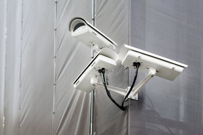 Drei Überwachungskameras auf Ecke des Gebäudes unter Wiederherstellungs- oder Erneuerungsfreien Überwachungskameras auf Wand des stockfotos Drei Überwachungskameras auf Ecke des Gebäudes unter Wiederherstellungs- oder Erneuerungsfreien Überwachungskameras auf Wand des stockfotos