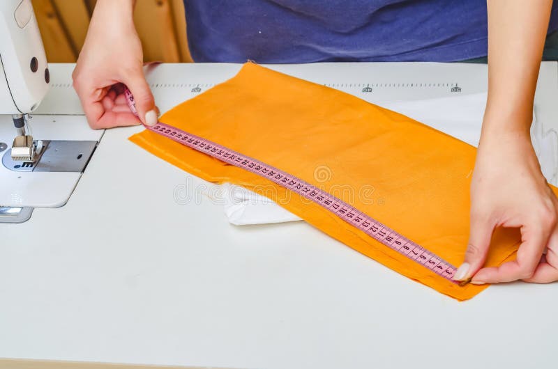 The Dressmaker Measures the Cloth for Sewing Clothes with Measuring