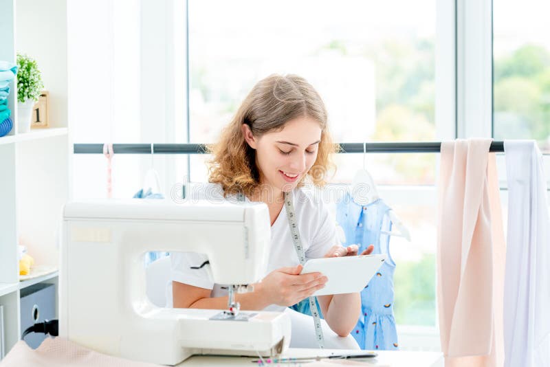 Dressmaker selecting sketch on tablet royalty free stock photography