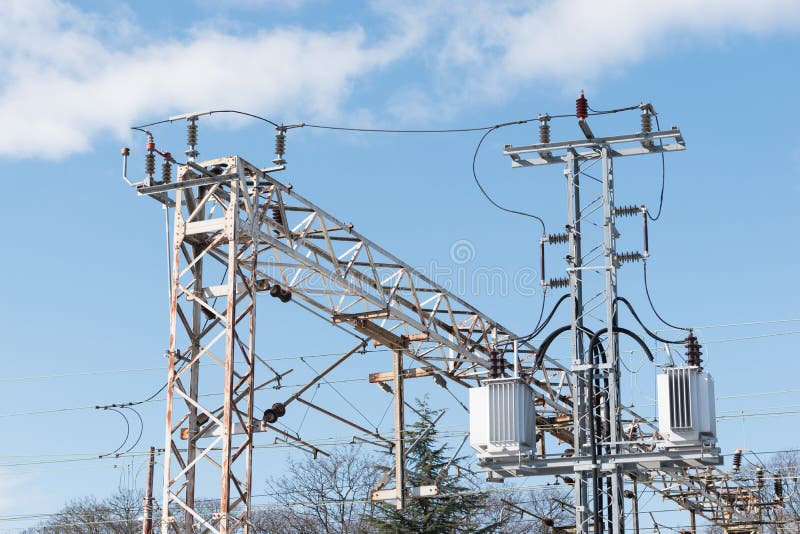Drev- eller järnvägkraftledningservice Järnväg kraftledningar med hög spänningselektricitet på metallpoler mot blå himmel royaltyfria bilder Drev- eller järnvägkraftledningservice Järnväg kraftledningar med hög spänningselektricitet på metallpoler mot blå himmel royaltyfria bilder