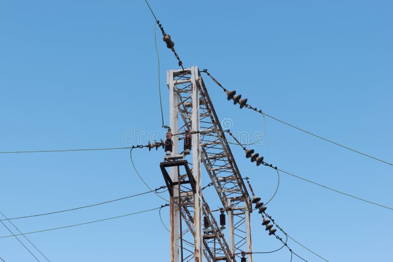 Drev- eller järnvägkraftledningservice Järnväg kraftledningar med hög spänningselektricitet på metallpoler mot blå himmel royaltyfri bild Drev- eller järnvägkraftledningservice Järnväg kraftledningar med hög spänningselektricitet på metallpoler mot blå himmel royaltyfri bild