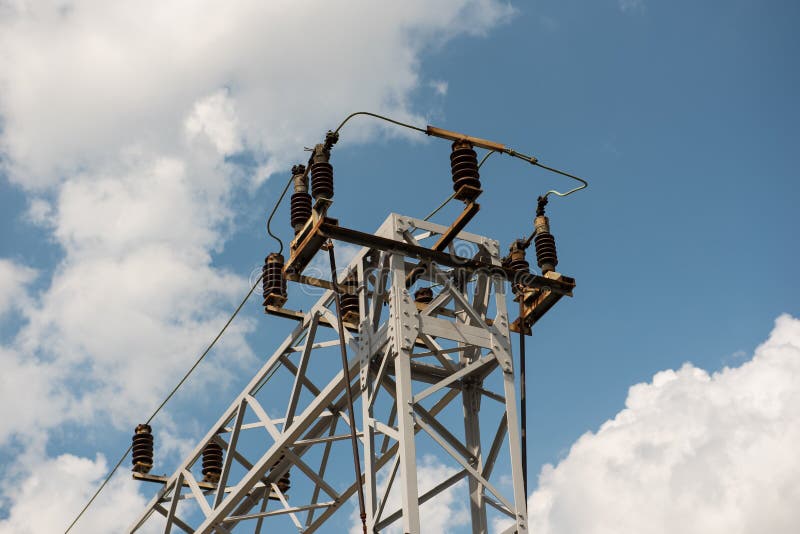 Drev- eller järnvägkraftledningservice Järnväg kraftledningar med hög spänningselektricitet på metallpoler mot blå himmel royaltyfri foto Drev- eller järnvägkraftledningservice Järnväg kraftledningar med hög spänningselektricitet på metallpoler mot blå himmel royaltyfri foto