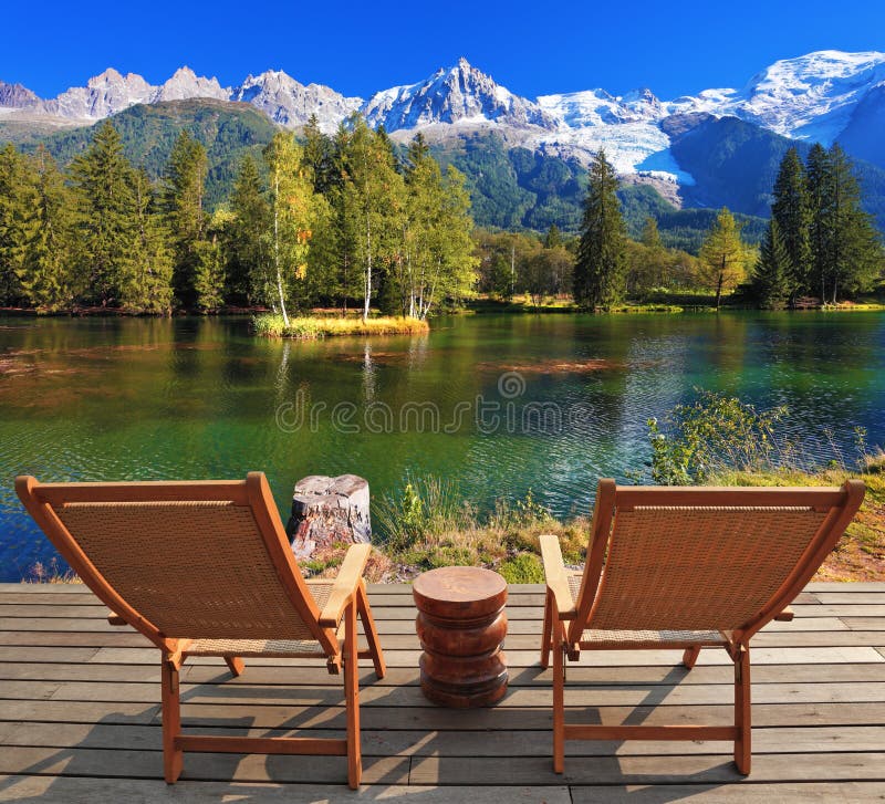 City park in the Alpine resort of Chamonix. Comfortable lounge chairs on wooden platform for rest and observation. City park in the Alpine resort of Chamonix. Comfortable lounge chairs on wooden platform for rest and observation