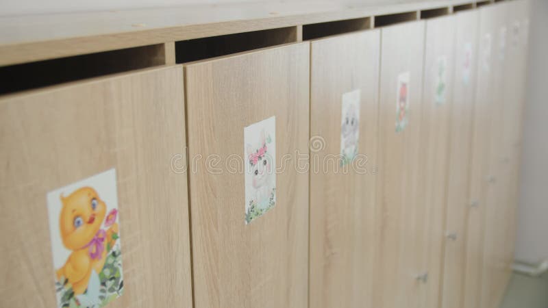Drewniane szafki z uroczymi obrazami w szatni dla dzieci