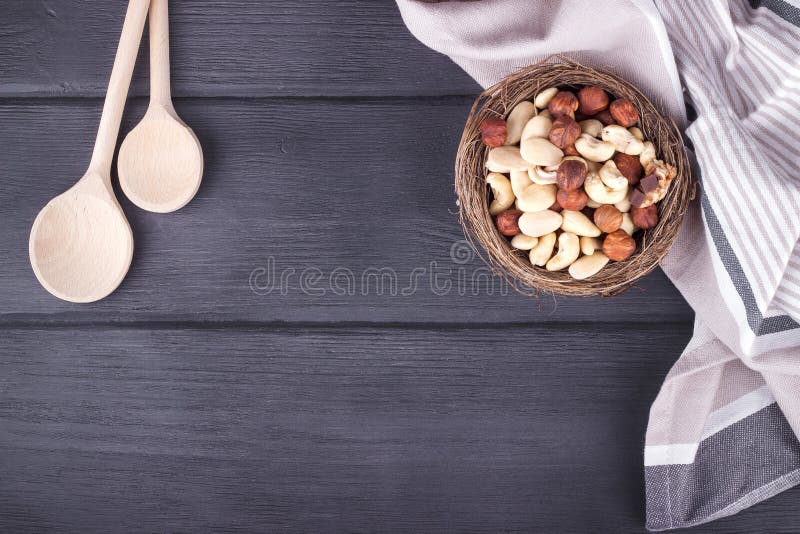 Drewniane łyżki, kuchenny ręcznik i puchar z mieszanymi dokrętkami na drewnie, zdjęcia stock Drewniane łyżki, kuchenny ręcznik i puchar z mieszanymi dokrętkami na drewnie, zdjęcia stock