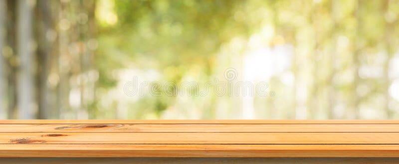 Drewnianej deski pustego stołu zamazany tło Perspektywiczny brown drewno stół nad plam drzew lasu tłem