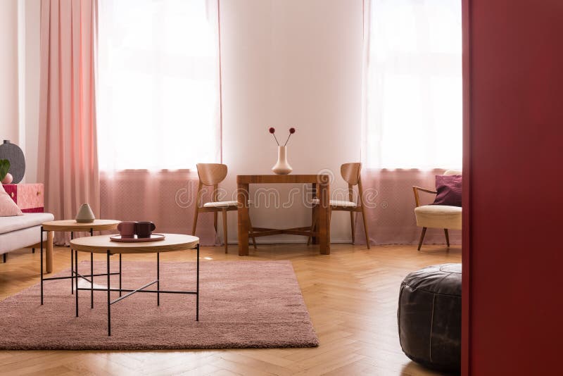 Drewniani stoły na purpurowym dywanie w żywym izbowym wnętrzu z menchiami drapują przy okno Istna fotografia