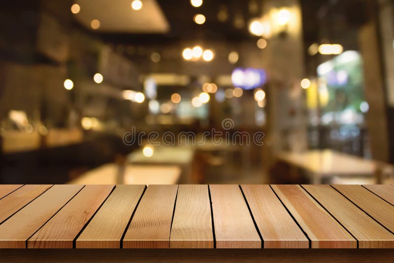 Drewniany stołowy wierzchołek na plamy bokeh cukiernianym tle może używać dla dis