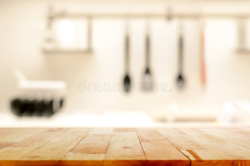 Drewniany stołowy wierzchołek na plamy kuchni tle (jako kuchenna wyspa)