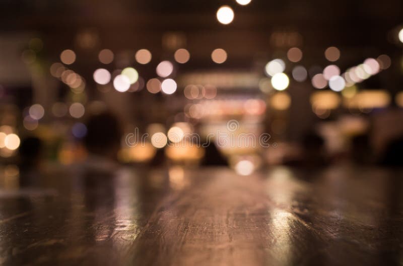 Drewniany stołowy wierzchołek z odbija na plamie oświetlenie w kawiarni, restauracja