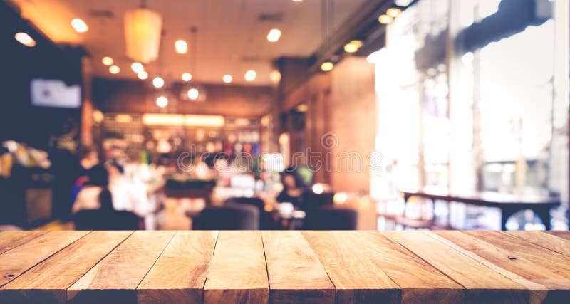 Drewniany stołowy wierzchołek z plamą ludzie w sklep z kawą lub kawiarni, restauracja