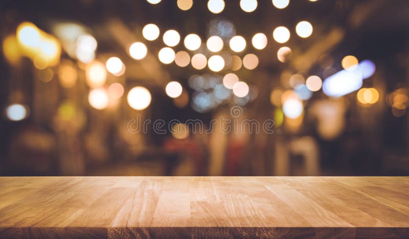 Drewniany stołowy wierzchołek z plamą oświetlenie w nocy ulicy kawiarni