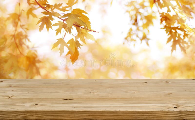Drewniany stół przed abstraktem zamazywał kolorowego jesieni tło fotografia stock