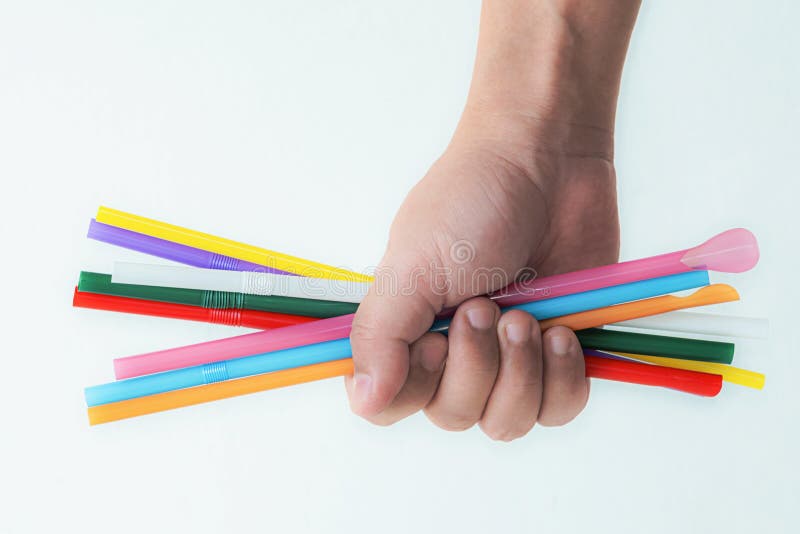 Dricksstrån av plast i handen arkivbild