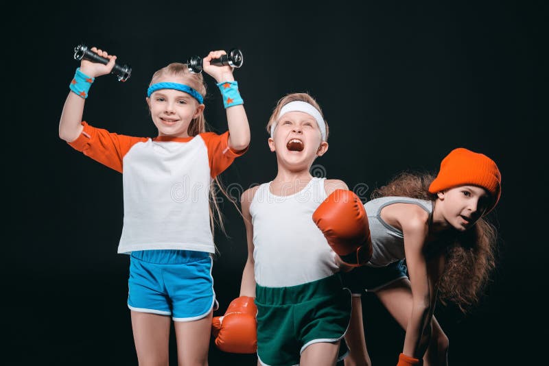 Drie actieve jonge geitjes in sportkleding het stellen met sportmateriaal royalty-vrije stock foto Drie actieve jonge geitjes in sportkleding het stellen met sportmateriaal royalty-vrije stock foto