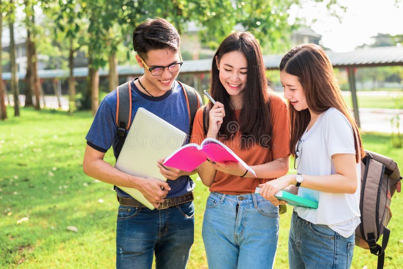 Three Asian young campus students enjoy tutoring and reading books together. Friendship and Education concept. Campus school and university theme. Happiness and funny of learning in college. Three Asian young campus students enjoy tutoring and reading books together. Friendship and Education concept. Campus school and university theme. Happiness and funny of learning in college