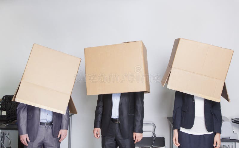 Drie bedrijfsmensen met dozen over hun hoofden in een bureau royalty-vrije stock afbeeldingen Drie bedrijfsmensen met dozen over hun hoofden in een bureau royalty-vrije stock afbeeldingen