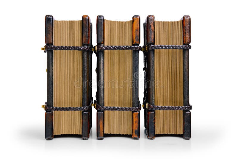 Drie boeken met houten die dekkingsplaten en leerhoeken, met gevlechte leerriemen worden gesloten bevinden zich tot de lijst die stock foto Drie boeken met houten die dekkingsplaten en leerhoeken, met gevlechte leerriemen worden gesloten bevinden zich tot de lijst die stock foto