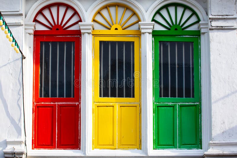 Drie gekleurde deuren of vensters buiten op de voorgevel van een oud huis stock fotografie Drie gekleurde deuren of vensters buiten op de voorgevel van een oud huis stock fotografie
